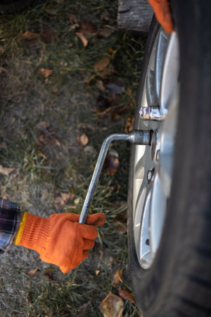 Close up of a car mechanic changing a tire with a wrench.の写真素材