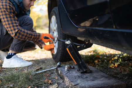 Close-up of a mechanic changing a tire on a car in the countrysideの写真素材
