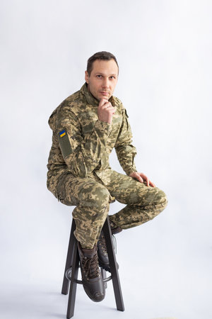 Full body Ukrainian soldier in military uniform sitting on white background.の写真素材