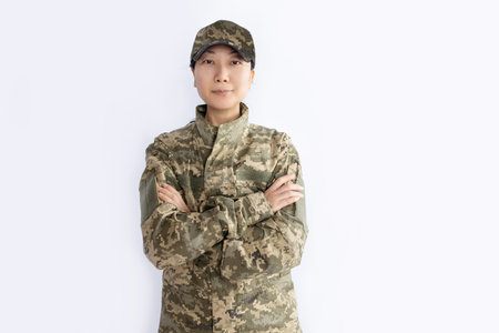 Close up of Asian female soldier wearing camouflage clothes looking at camera isolated on white background.の写真素材