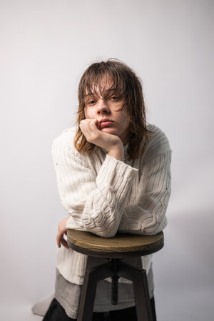 Closeup of a Young teen girl in white sweater isolated on a white background - people and moods conceptの写真素材