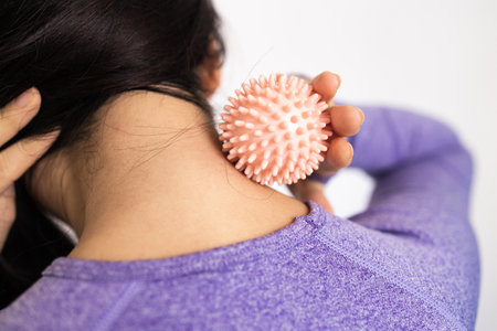 Close-up of a woman massaging her neck with a massage ballの写真素材