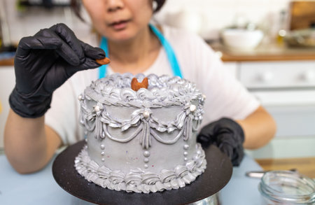 Female confectioner decorating cake in kitchen, Confectioner is decorating creamy cake, cooking class, culinary, bakery, food and people concept.の写真素材