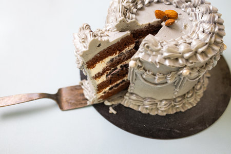 A sliced view of the stylish silver cake, revealing its luscious layers of chocolate sponge, whipped...