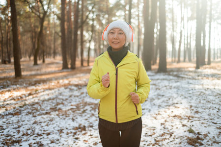 Woman jogging in winter forest. Sport and healthy lifestyle concept.の写真素材
