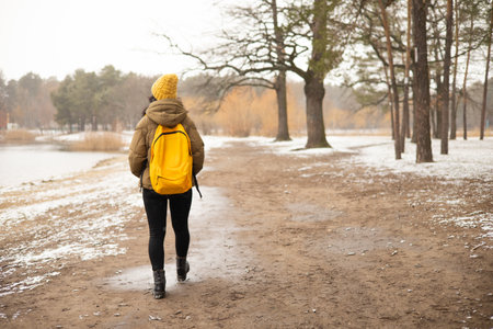 Back view of a hiker woman breathing fresh air in a foggy forest in winter