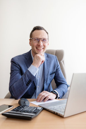 Portrait of a confident mature businessman sitting at his desk in an officeの写真素材