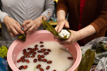 Group of Chinese woman is making zongzi by hand. Zongzi is a traditional Chinese snack.の写真素材