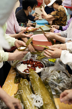 Group of Chinese woman is making zongzi by hand. Zongzi is a traditional Chinese snack.の写真素材