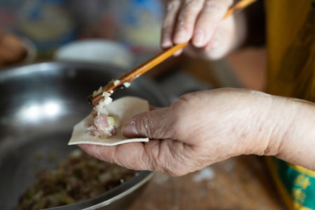 Close-up of the hands of a senior woman cooking dumplingsの写真素材
