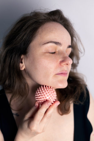 neck massage with spiky pink massage ball for muscle pain relieve and myofascial releaseの写真素材
