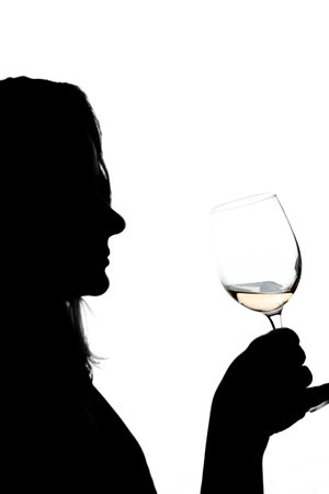 Woman drinking wine on white background. Shadow silhouette of female person celebrating holiday in bar. Romantic evening.の写真素材