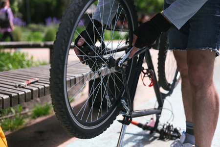 The cyclist repairs and changes the tire on his bike in park. Bicycle tire repair. Selective focus....