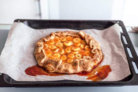 Close-up of a freshly baked pie. The pie has a golden brown crust and delicious-looking filling. The fresh baked sweet banana pie with jam.の写真素材