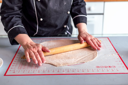 Close up view of baker is working. Homemade pie. Hands preparing dough on table.