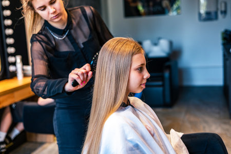 Female hairdresser cutting hair of young woman in beauty salonの写真素材