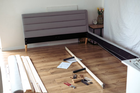 The furniture assembler assembles the bed frame, do it yourself and assemble new furnitureの写真素材