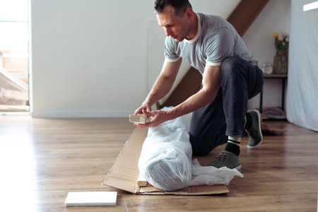 The furniture assembler assembles the bed frame, do it yourself and assemble new furnitureの写真素材