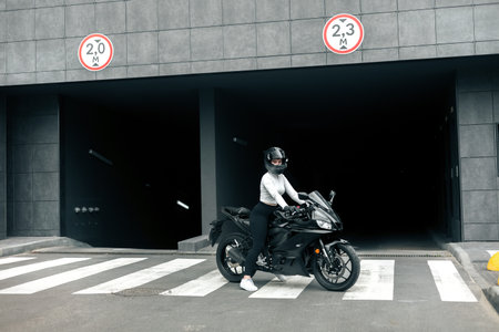 Biker crossing the road at the front of a building in the city
