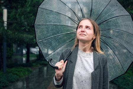 Portrait of a young woman with an umbrella in the rain.