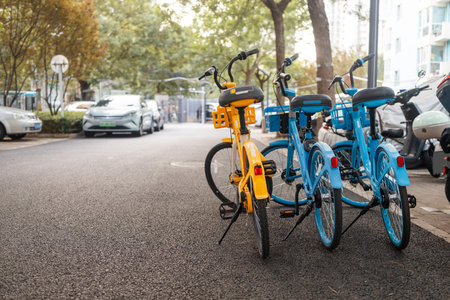 Colorful rental bicycles parked along a busy sidewalk across the street in China.