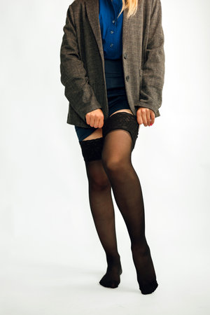 Woman with beautiful long legs wearing black tights on white background, closeup. Copy space.の写真素材