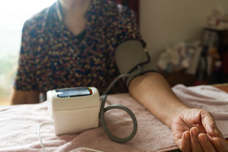 Close up of senior woman measuring her blood pressure with digital blood pressure monitor