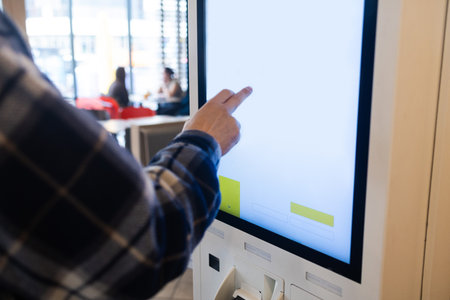 Selective focus to customer's hand is touching a touch screen to order food and pay electronically.の写真素材