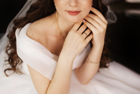 Wedding photography, close-up portrait of a beautiful young bride in a white dress with a rings, necklace on her neck.の写真素材