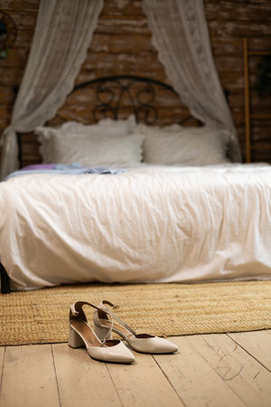 Closeup surface view of high heeled shoes by bed. Bride Bridal Wedding Shoes.の写真素材