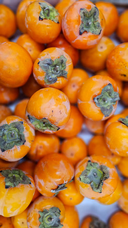 Fresh persimmon fruit in the market, closeup of photoの写真素材
