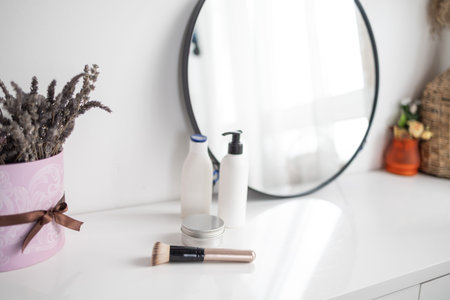 Cosmetics on a dressing table in front of a mirror in a bathroomの写真素材