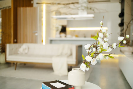 Bouquet of cherry blossom in vase on table in bright living room. Home decor, interior design.の写真素材