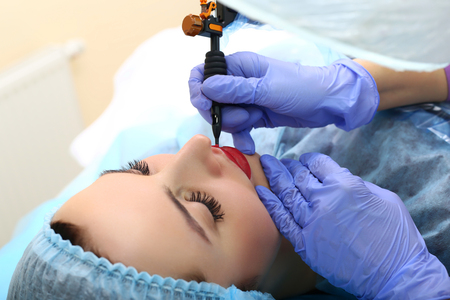 Healthy Spa: Young Beautiful Woman Having Permanent Make-up Tattoo on her Lips. Close-upの写真素材