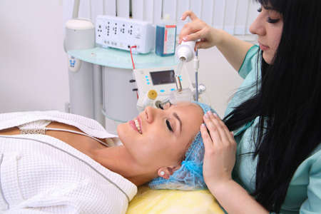 People, beauty, spa, cosmetology and technology concept - close up of beautiful young woman lying...
