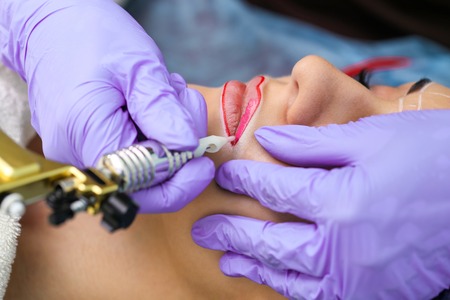 Healthy Spa: Young Beautiful Woman Having Permanent Make-up Tattoo on her Lips. Close-upの写真素材