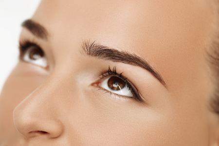 Cosmetologist applying permanent make up on eyebrows- eyebrow tattooの写真素材