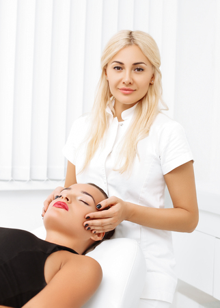 Close-up of a young woman getting spa treatment at beauty salon. spa face massage. facial beauty treatment. spa salon.の写真素材