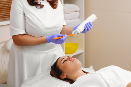 Applying cosmetic gel on the face patient.の写真素材
