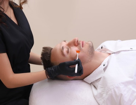 Cleaning the face of a man in a beauty salon.の写真素材