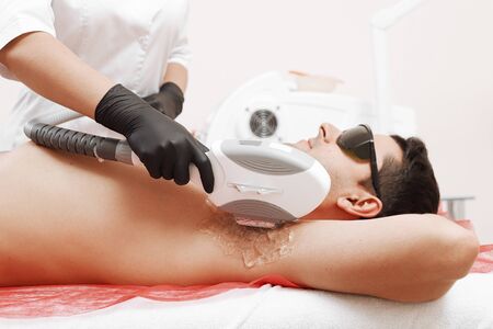Therapist Giving Laser Epilation Treatment To Young Man In Spaの写真素材