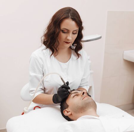 The cosmetologist makes the procedure Microdermabrasionの写真素材
