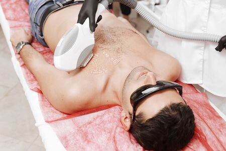 Therapist Giving Laser Epilation Treatment To Young Man In Spaの写真素材