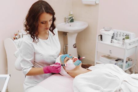 Spa Woman applying Facial cleansing Mask.の写真素材