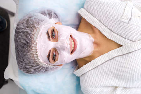 Beautiful woman with facial mask at beauty salonの写真素材