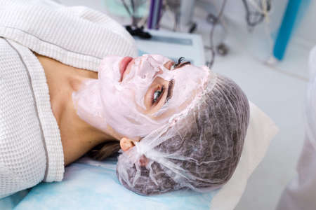 Beautiful woman with facial mask at beauty salonの写真素材