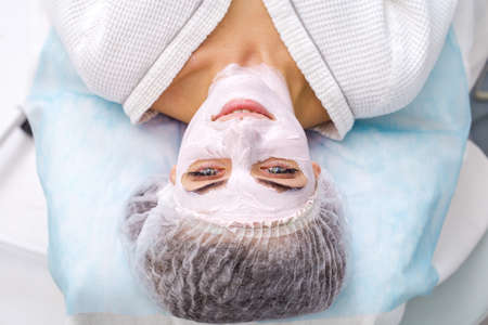 Beautiful woman with facial mask at beauty salonの写真素材