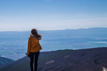 Girl standing on the edge and looking over a clifの写真素材