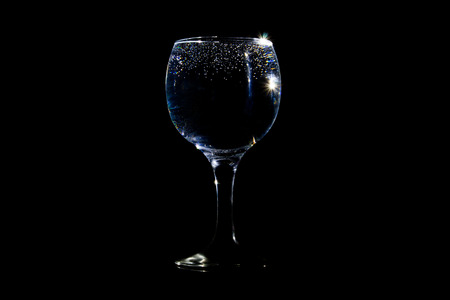 Glass of water with tiny bubbles on black backgroundの写真素材