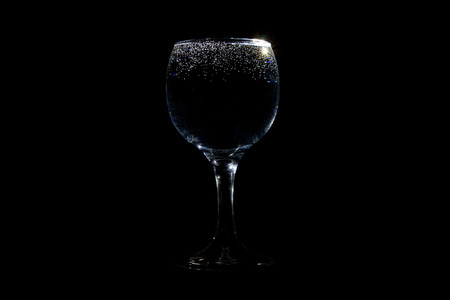 Glass of water with tiny bubbles on black backgroundの写真素材